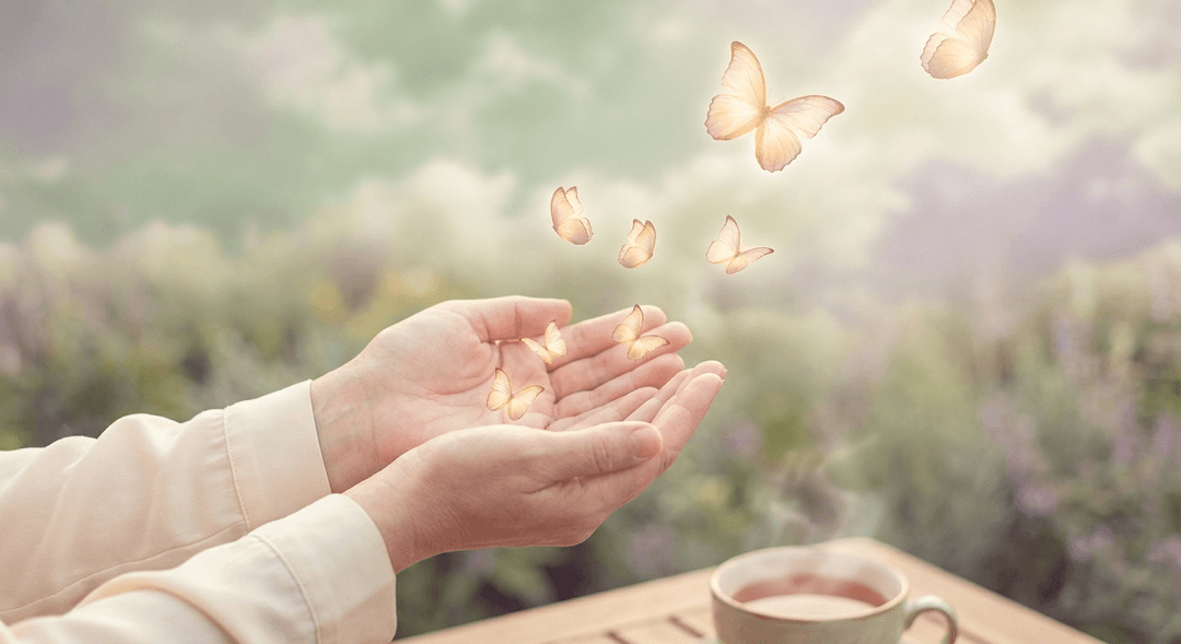 Gentle hands releasing luminous butterflies into morning light